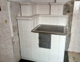 Nasze realizacje - Kuchnie kaflowe NR-KU-44 - Narożna kuchnia kaflowa z kafli typu okno modułu 25cm. Nad kuchnia prosty okap z kafelkami płytkami u podstawy. projekt: Marcin Deręgowski