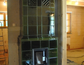 Nasze realizacje - Piece kaflowe NR-PK-40 - Piec kaflowy wykonany z kafli ceramicznych - szkliwo zieleń oliwkowa. Klasyczna bryła dwu-skrzyniowa z przewężeniem w połowie pieca. Piec zasila wodny wkład z płaszczem wodnym Brunner z elektronicznym sterowaniem procesem spalania. projekt: Marcin Deręgowski
