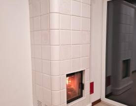 Nasze realizacje - Piece kaflowe NR-PK-65 - Piec kaflowy z wkładem kominkowym Hajduk i masą akumulacyjną (kegi akumulacyjne) na wyjściu spalin. Kafle ceramiczne w szkliwie biały mat (satyna) przekładane kaflami typu serwetka. Wokół paleniska ramka kaflowa. Całość grzeje po wygaśnieciu kilka godzin. projekt: Marcin Deręgowski